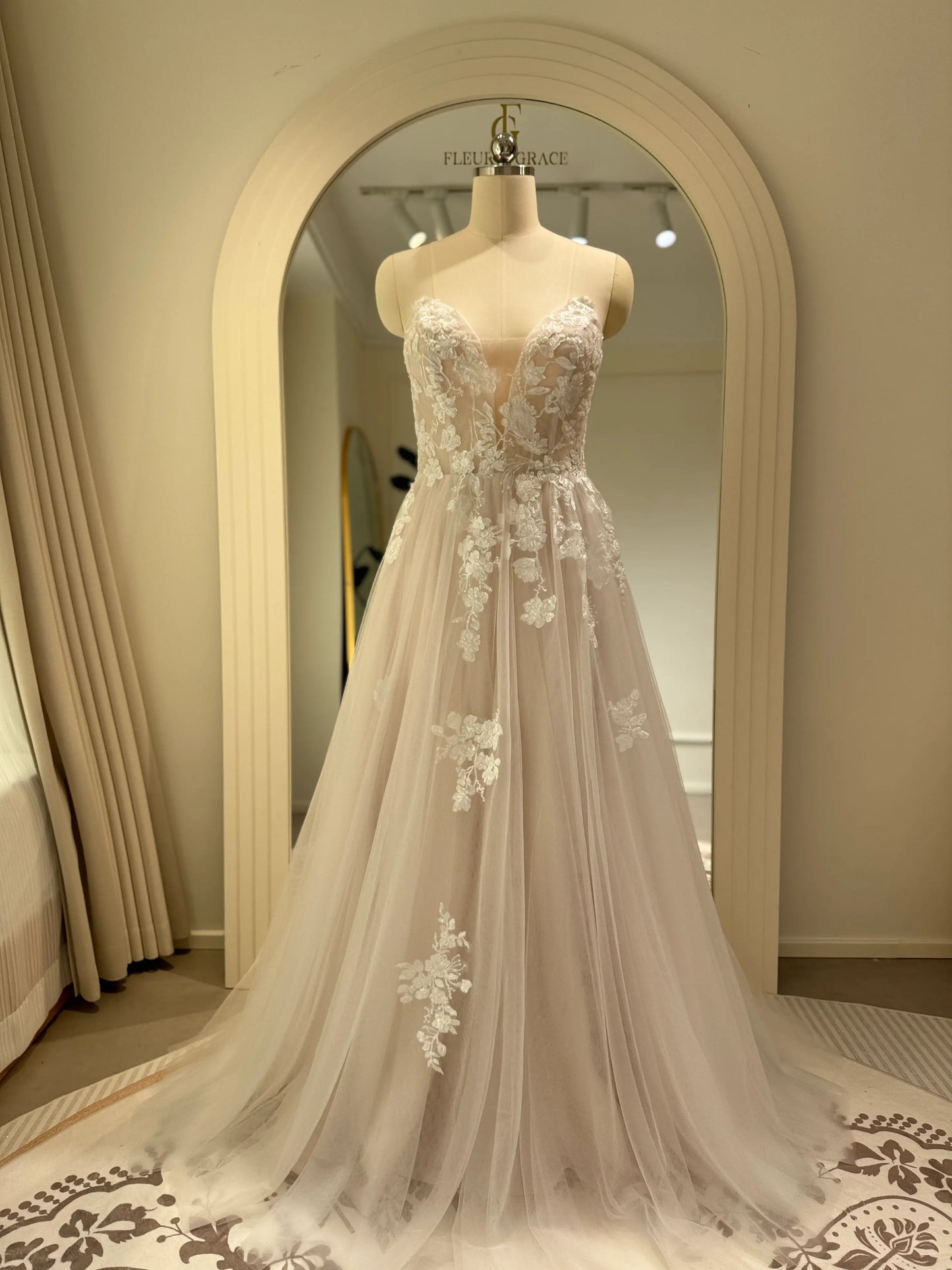 Aure Gown by Fleur&Grace Designs – romantic floral embroidered wedding dress with plunging neckline, removable long sleeves, soft tulle skirt, and A-line silhouette, perfect for whimsical weddings and elopements.