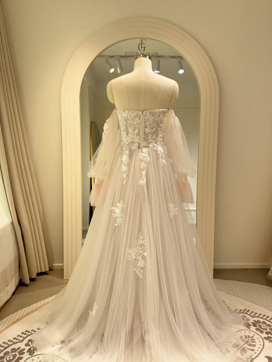 Aure Gown by Fleur&Grace Designs – romantic floral embroidered wedding dress with plunging neckline, removable long sleeves, soft tulle skirt, and A-line silhouette, perfect for whimsical weddings and elopements.