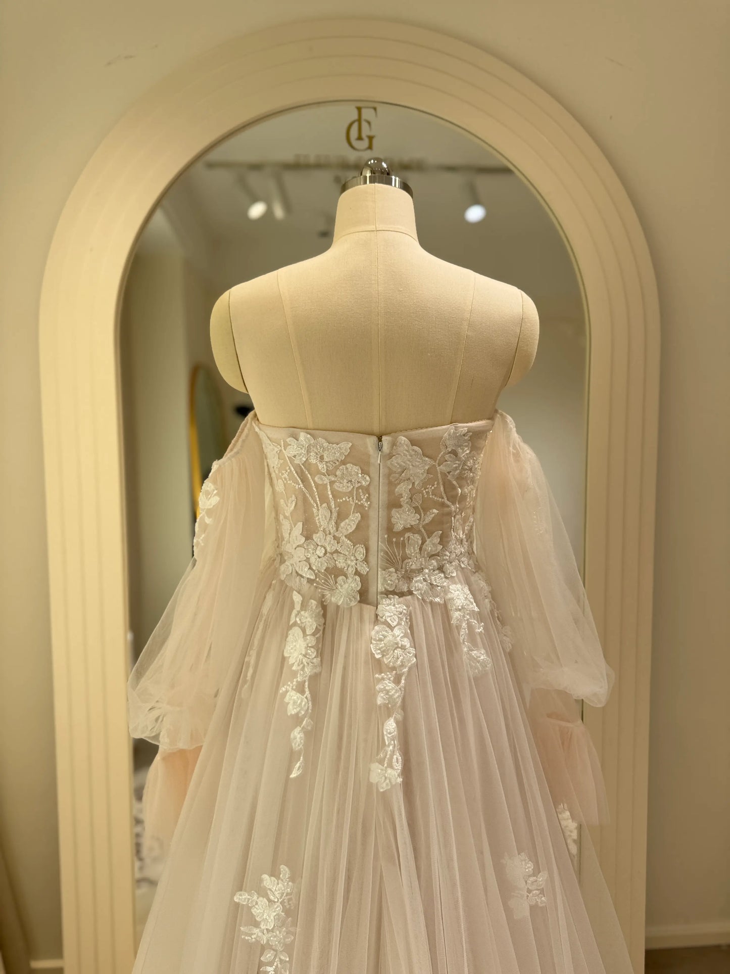 Aure Gown by Fleur&Grace Designs – romantic floral embroidered wedding dress with plunging neckline, removable long sleeves, soft tulle skirt, and A-line silhouette, perfect for whimsical weddings and elopements.