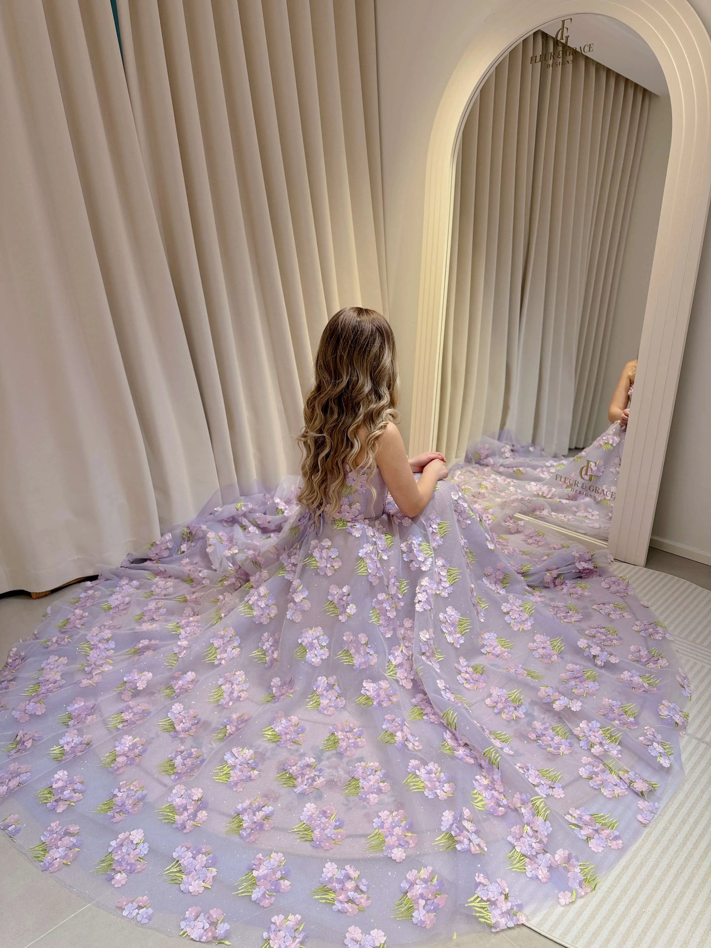 Model wearing the Lavender Elysia Gown FG016 by Fleur&Grace Designs – floor-length lavender dress with 3D hydrangea floral lace, sparkly mesh lining, and lace-up back, perfect for prom, garden weddings, formal evenings, and whimsical photography.