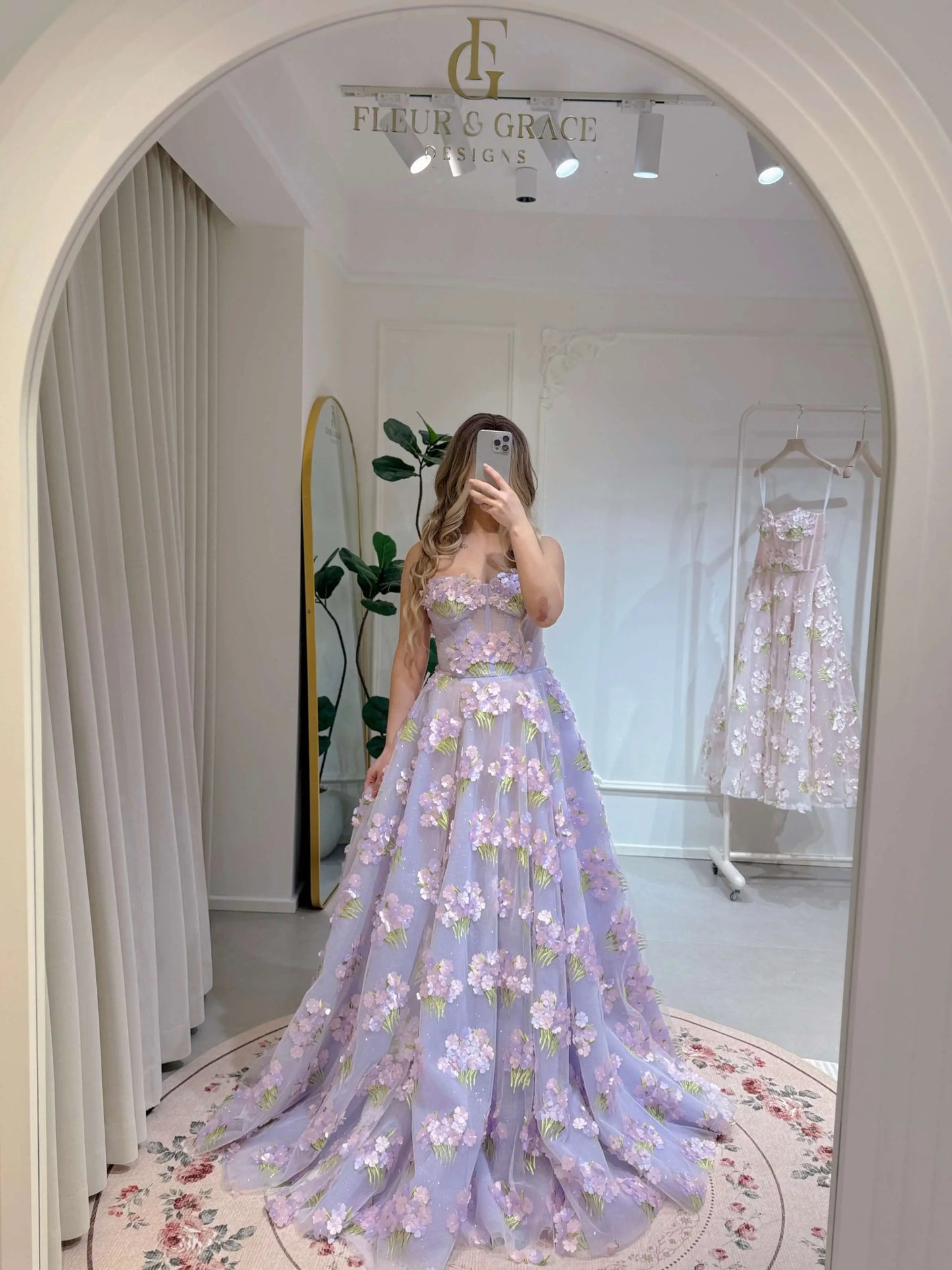 Model wearing the Lavender Elysia Gown FG016 by Fleur&Grace Designs – floor-length lavender dress with 3D hydrangea floral lace, sparkly mesh lining, and lace-up back, perfect for prom, garden weddings, formal evenings, and whimsical photography.