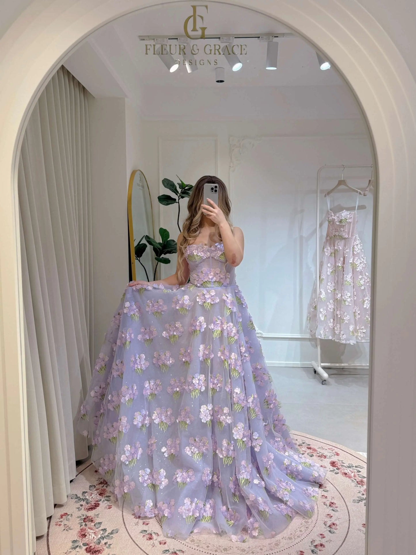 Model wearing the Lavender Elysia Gown FG016 by Fleur&Grace Designs – floor-length lavender dress with 3D hydrangea floral lace, sparkly mesh lining, and lace-up back, perfect for prom, garden weddings, formal evenings, and whimsical photography.
