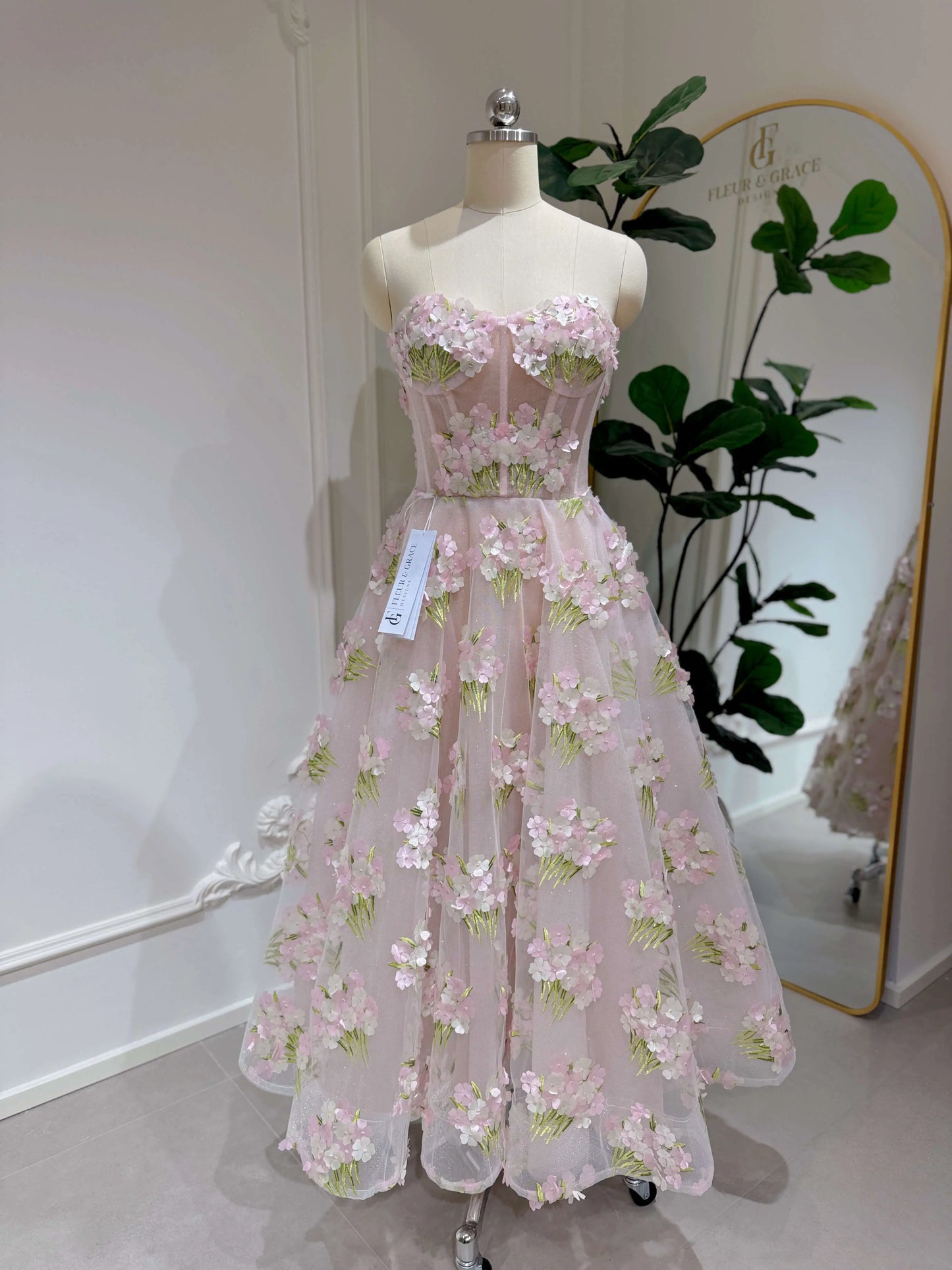 Model wearing the Elysia gown by Fleur&Grace Designs, a pink ankle-length dress made with 3D hydrangea floral lace, sparkly mesh lining, and lace-up back – perfect for prom, formal events, garden weddings, and whimsical photography.