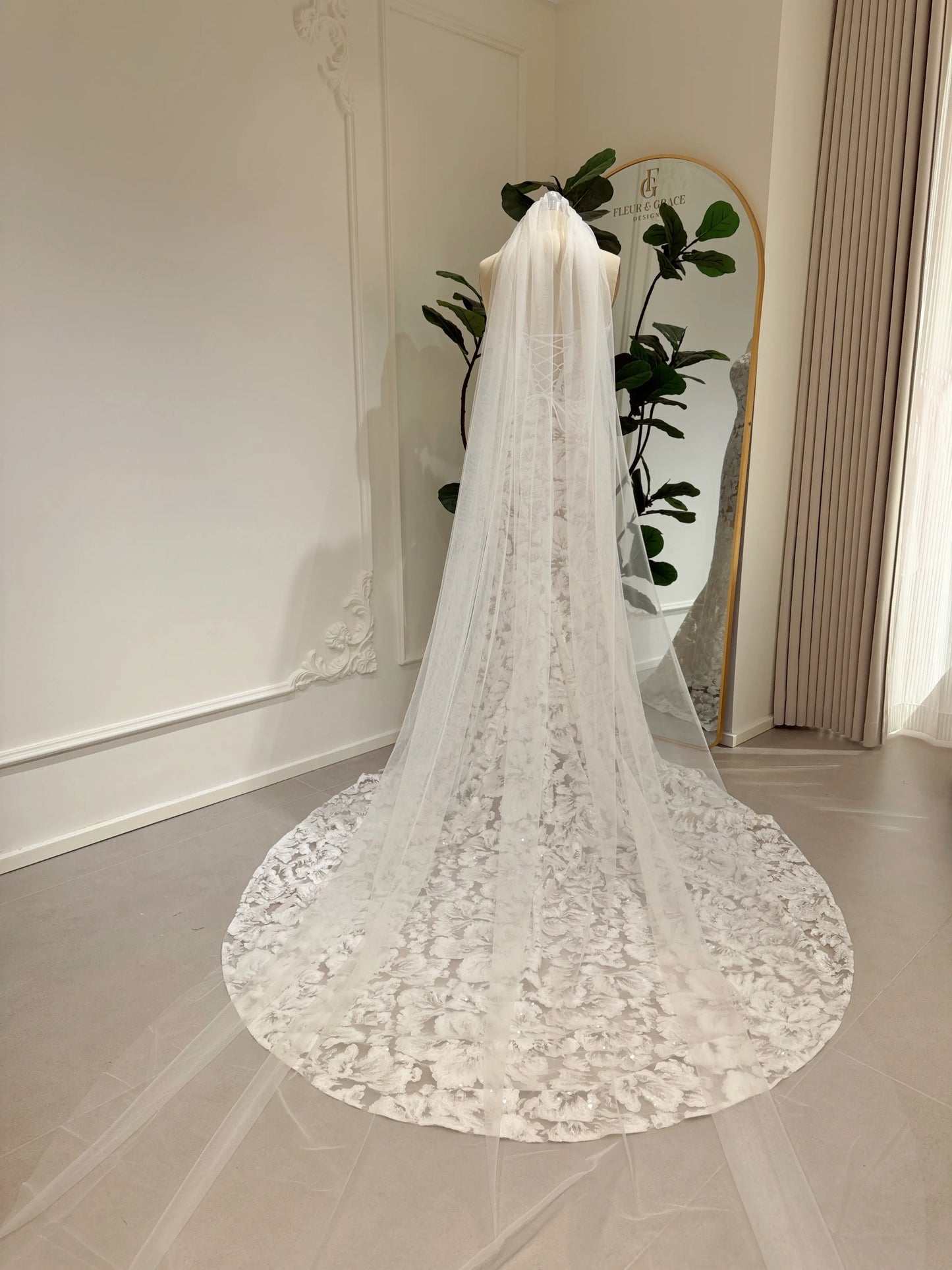 Mannequin wearing the Jane Gown by Fleur&Grace Designs – strapless mermaid wedding dress with floral embroidered lace, glitter sequins, lace‑up back, and chapel‑length train.
