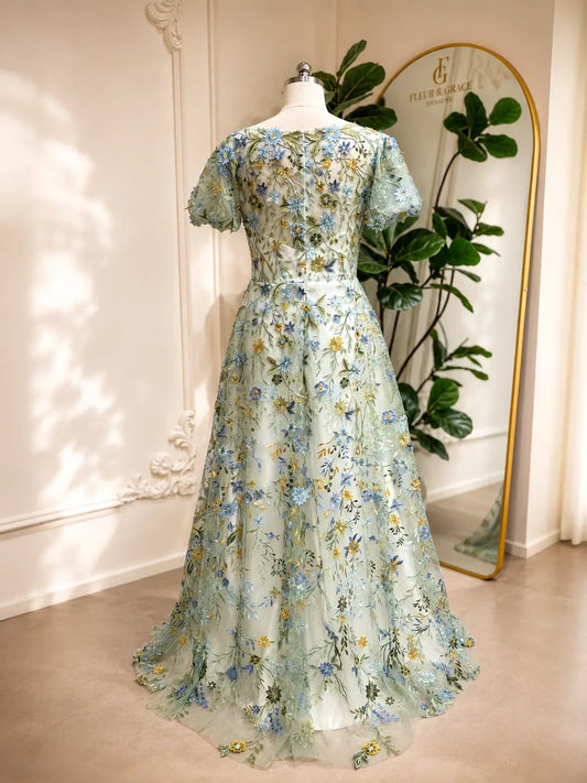Meadow green A-line wedding dress with puff sleeves and intricate blue and yellow floral tulle embroidery.