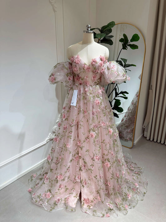 Pink 3D floral organza prom gown with removable puffy sleeves, sweetheart neckline, and green leaf embroidery.