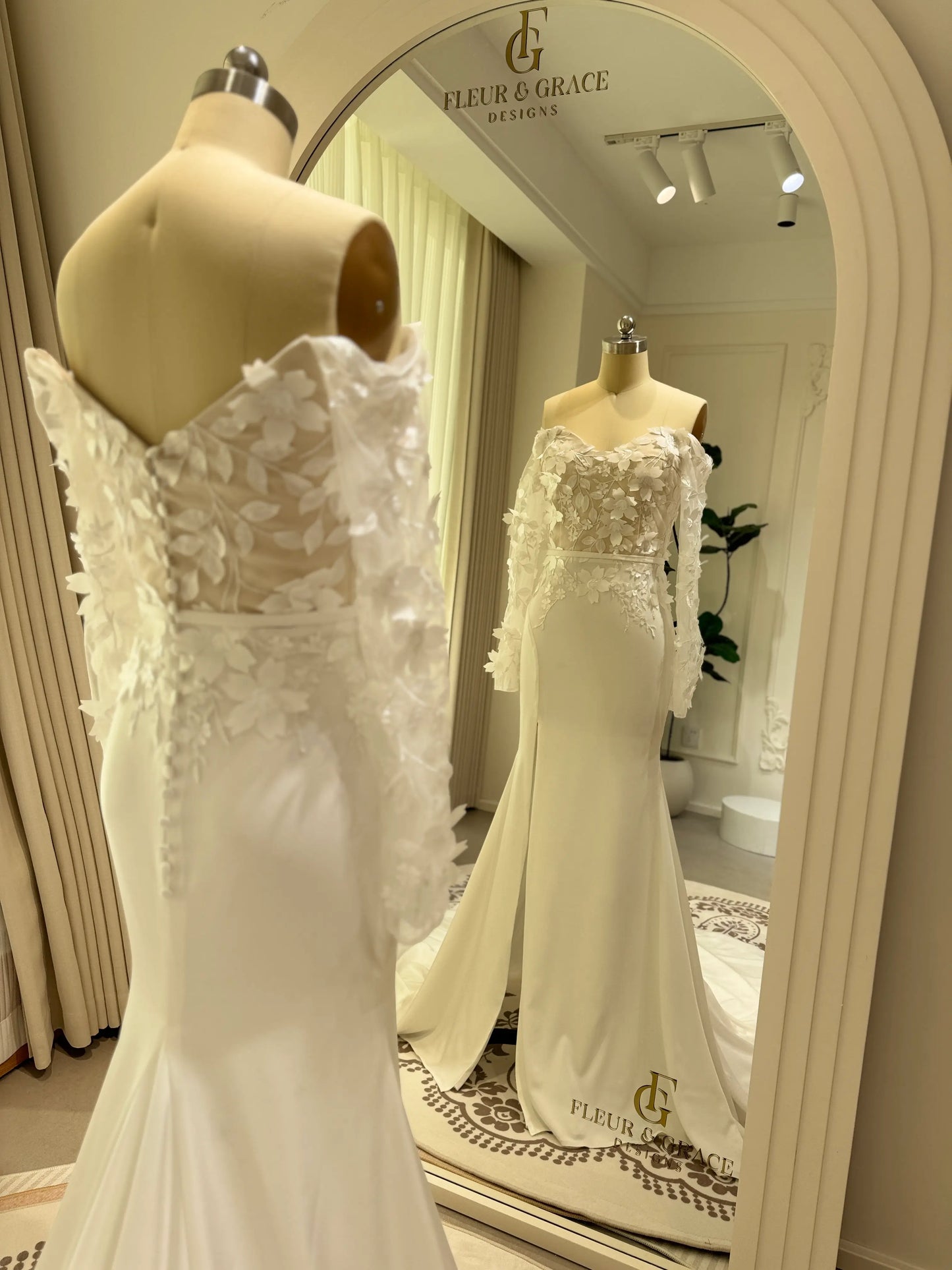 Zoe Gown by Fleur&Grace – minimalist matte crepe wedding dress with 3D floral lace bodice, long off-the-shoulder sleeves, side slit, and train, perfect for modern and romantic weddings.