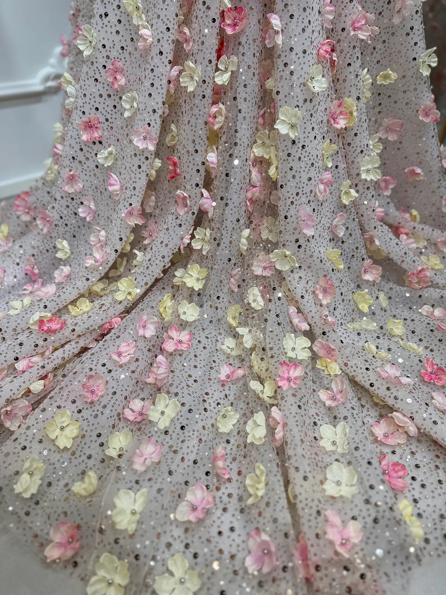 Shimmering beaded lace fabric with handmade 3D pink and yellow floral appliqués for the Alice Gown.