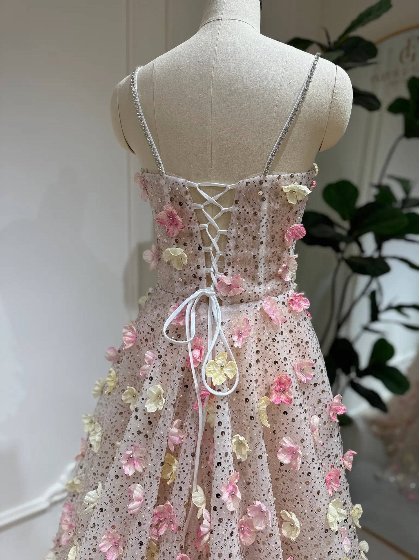 Alice Gown with pink and yellow 3D floral lace, beaded shimmer, stone-accented straps, and a lace-up back on a mannequin.