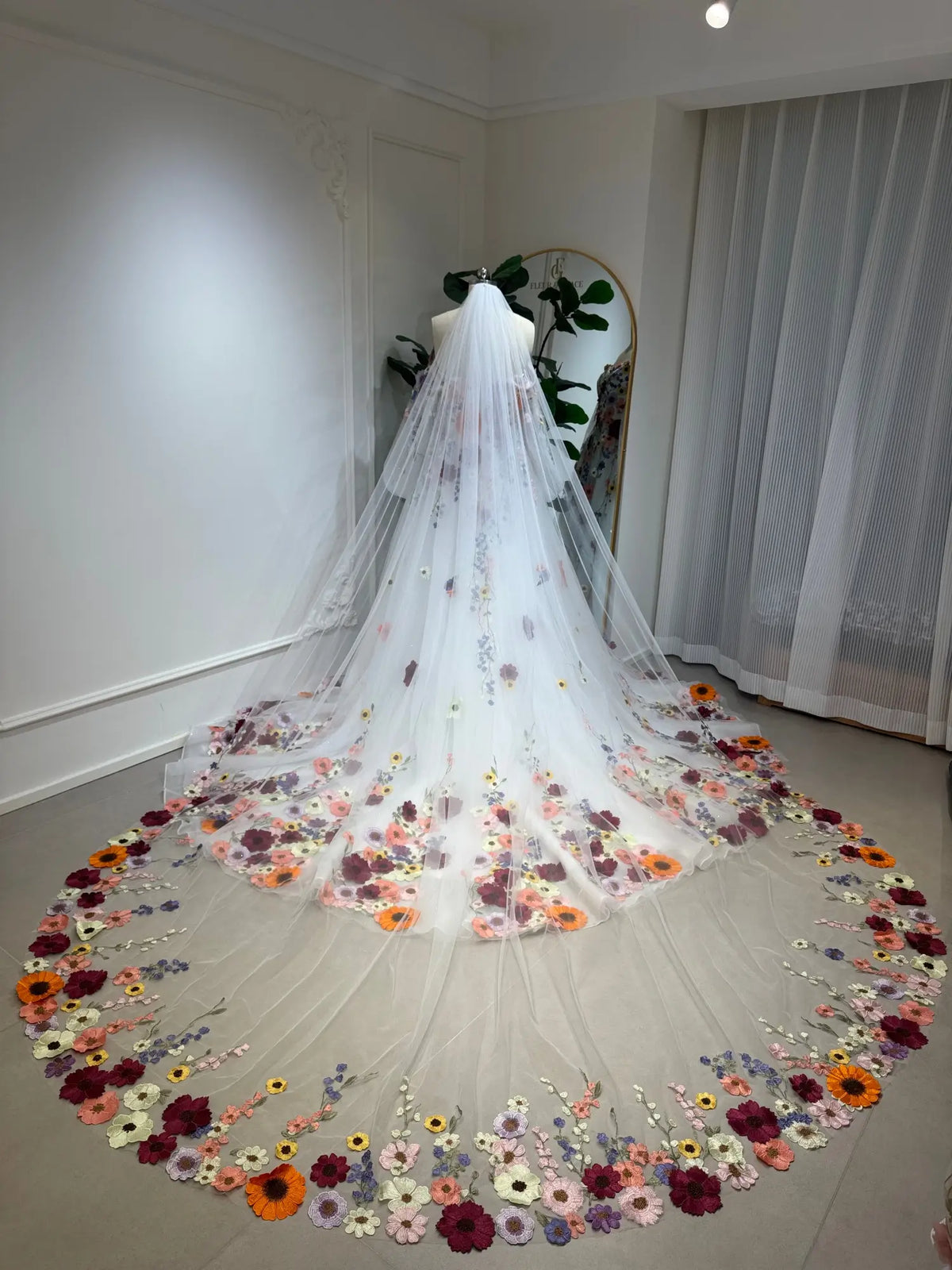 Cathedral-length white tulle wedding veil featuring vibrant, handcrafted 3D floral embroidery along the sweeping hem.