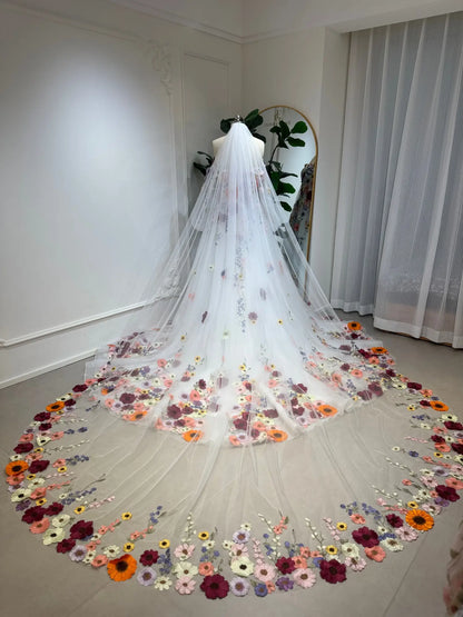 Cathedral-length white tulle wedding veil featuring vibrant, handcrafted 3D floral embroidery along the sweeping hem.
