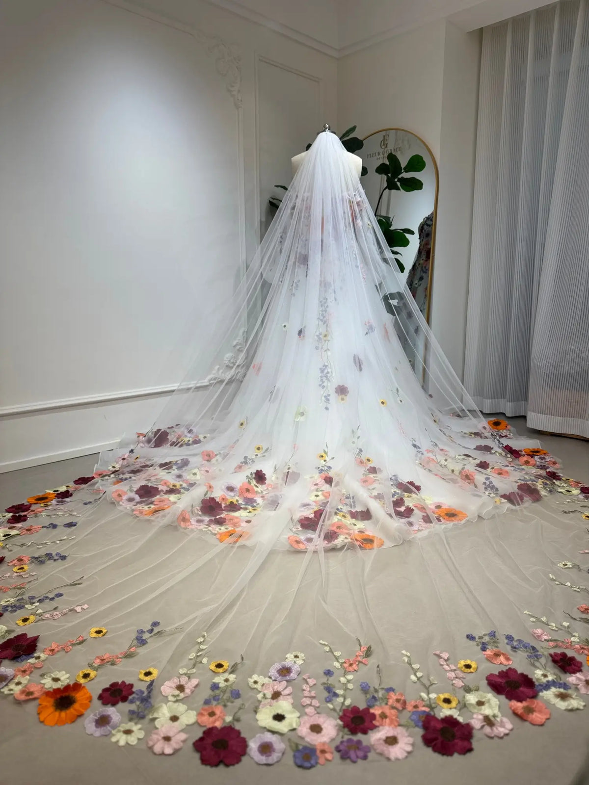 Cathedral-length white tulle wedding veil featuring vibrant, handcrafted 3D floral embroidery along the sweeping hem.
