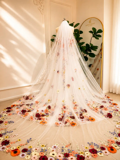Cathedral-length white tulle wedding veil featuring vibrant, handcrafted 3D floral embroidery along the sweeping hem.
