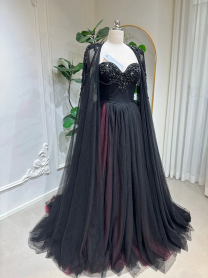Black and burgundy A-line wedding dress with a beaded corset bodice and a detachable sheer illusion cape.