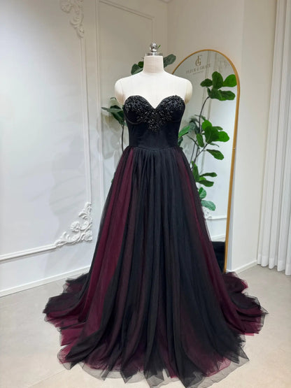 Black and burgundy A-line wedding dress with a beaded sweetheart corset bodice and layered tulle skirt.