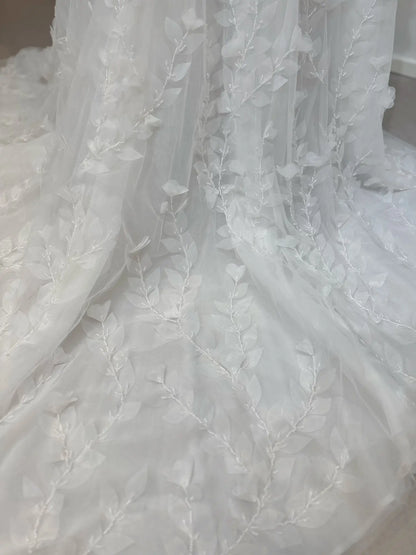 White tulle wedding dress fabric featuring delicate 3D leaf appliqués and intricate hand-sewn beading detail.