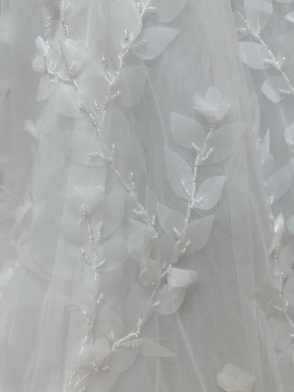 White tulle wedding dress fabric with delicate 3D floral leaf appliqués and intricate hand-sewn bead detailing.