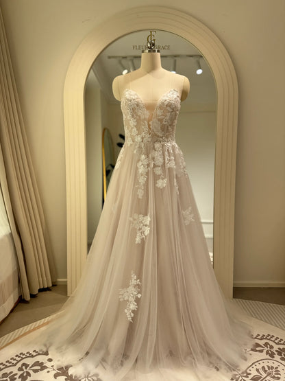 Ivory A-line wedding gown with floral embroidery on tulle, featuring a plunging illusion V-neckline on a structured bodice.