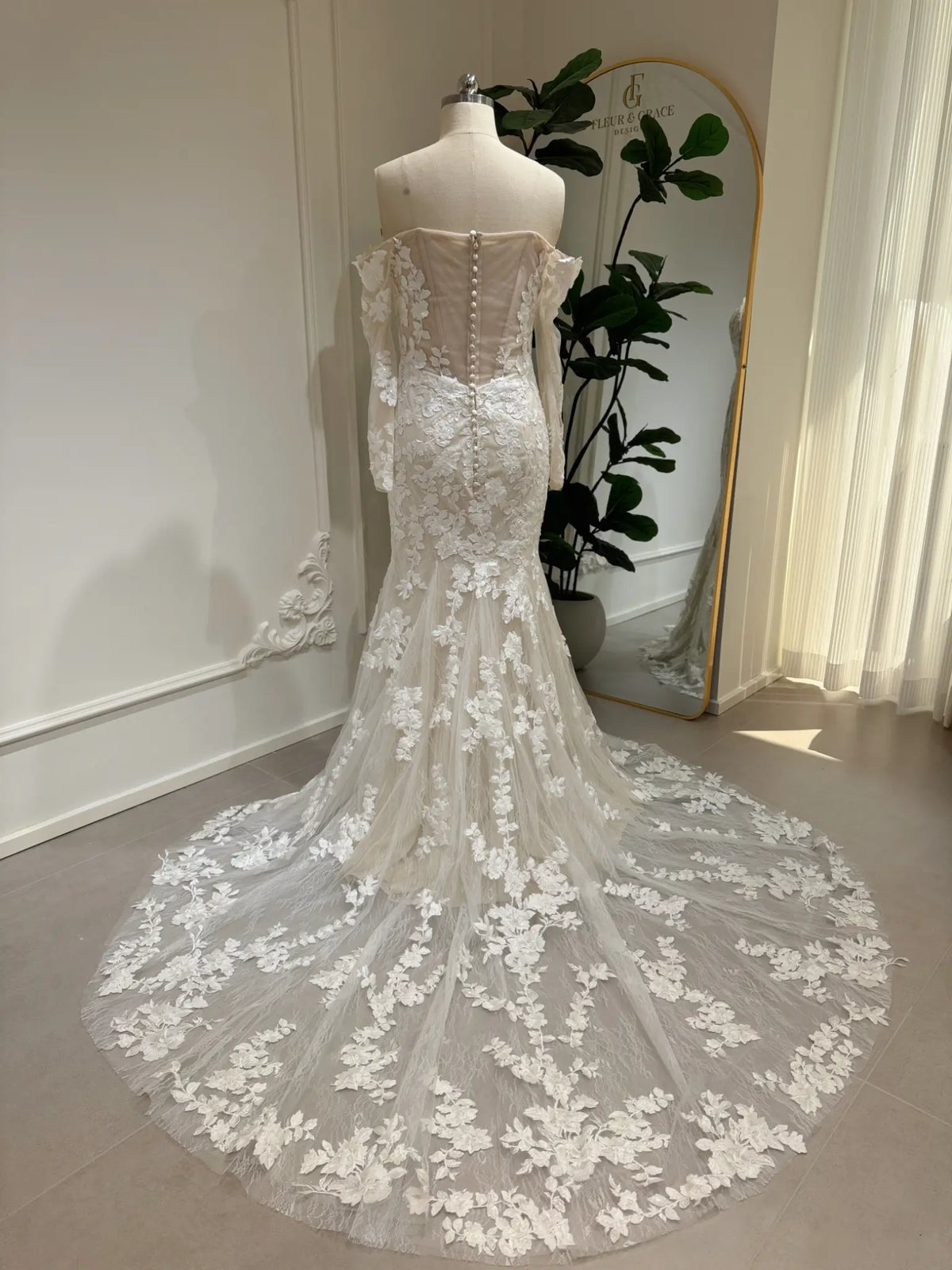 Back view of Ayla mermaid wedding dress with floral embroidery, off-shoulder sleeves, and a long lace court train.