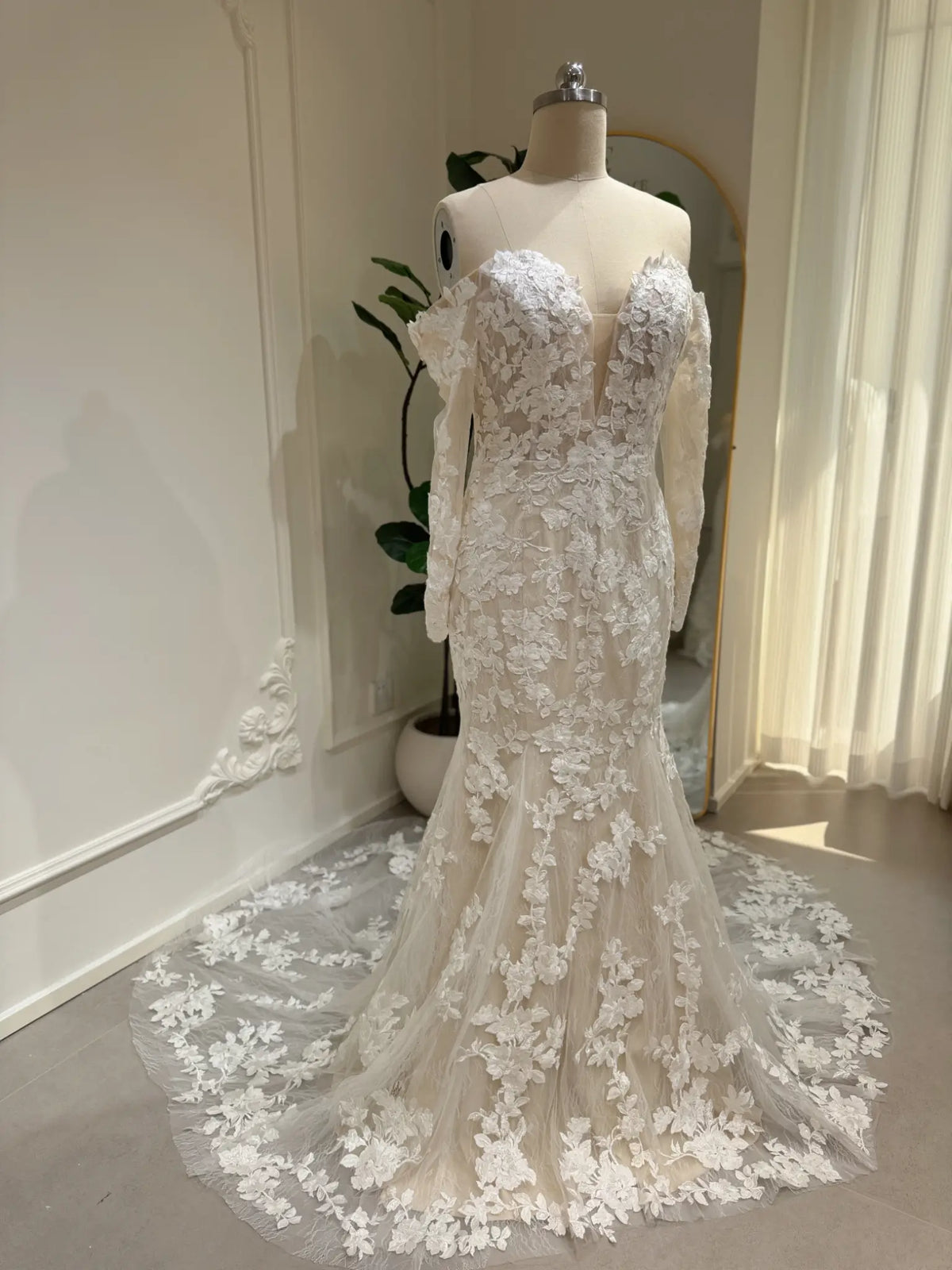 Mermaid wedding dress with floral embroidery, off-the-shoulder long sleeves, and a plunging sweetheart neckline.