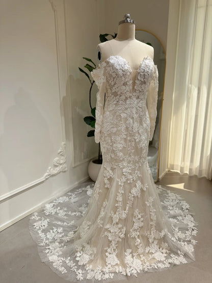 Mermaid wedding dress with floral embroidery, off-the-shoulder long sleeves, and a plunging sweetheart neckline.