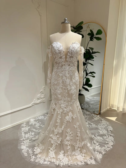 Mermaid wedding dress with floral embroidery, off-shoulder long sleeves, plunging sweetheart neckline, and lace train.