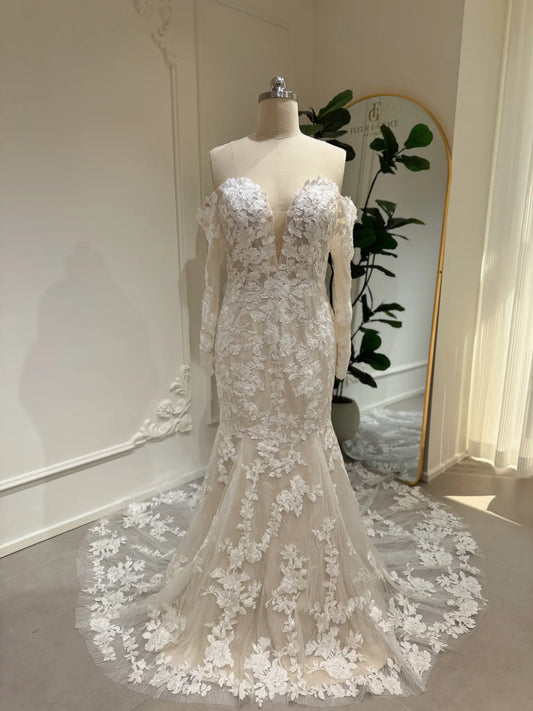 Mermaid wedding dress with floral embroidery, off-shoulder long sleeves, plunging sweetheart neckline, and lace train.