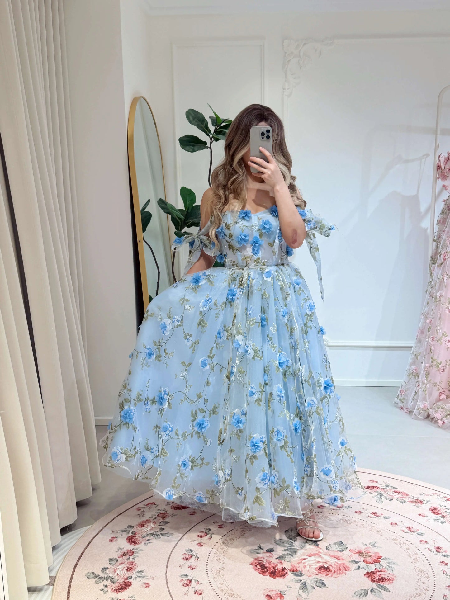 Blue ankle-length gown with 3D floral organza, green leaf prints, sweetheart neckline, and tie-shoulder straps.