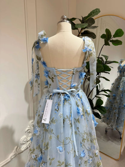 Blue ankle-length gown with 3D floral organza, green leaf prints, sweetheart neckline, and adjustable lace-up back.
