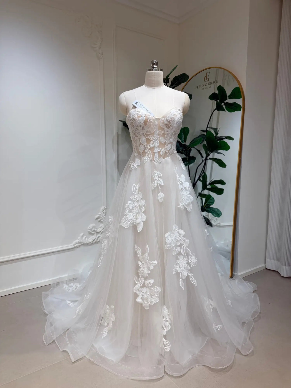 Strapless A-line wedding dress with a sweetheart neckline, 3D floral lace appliqués, and a flowing tulle skirt.