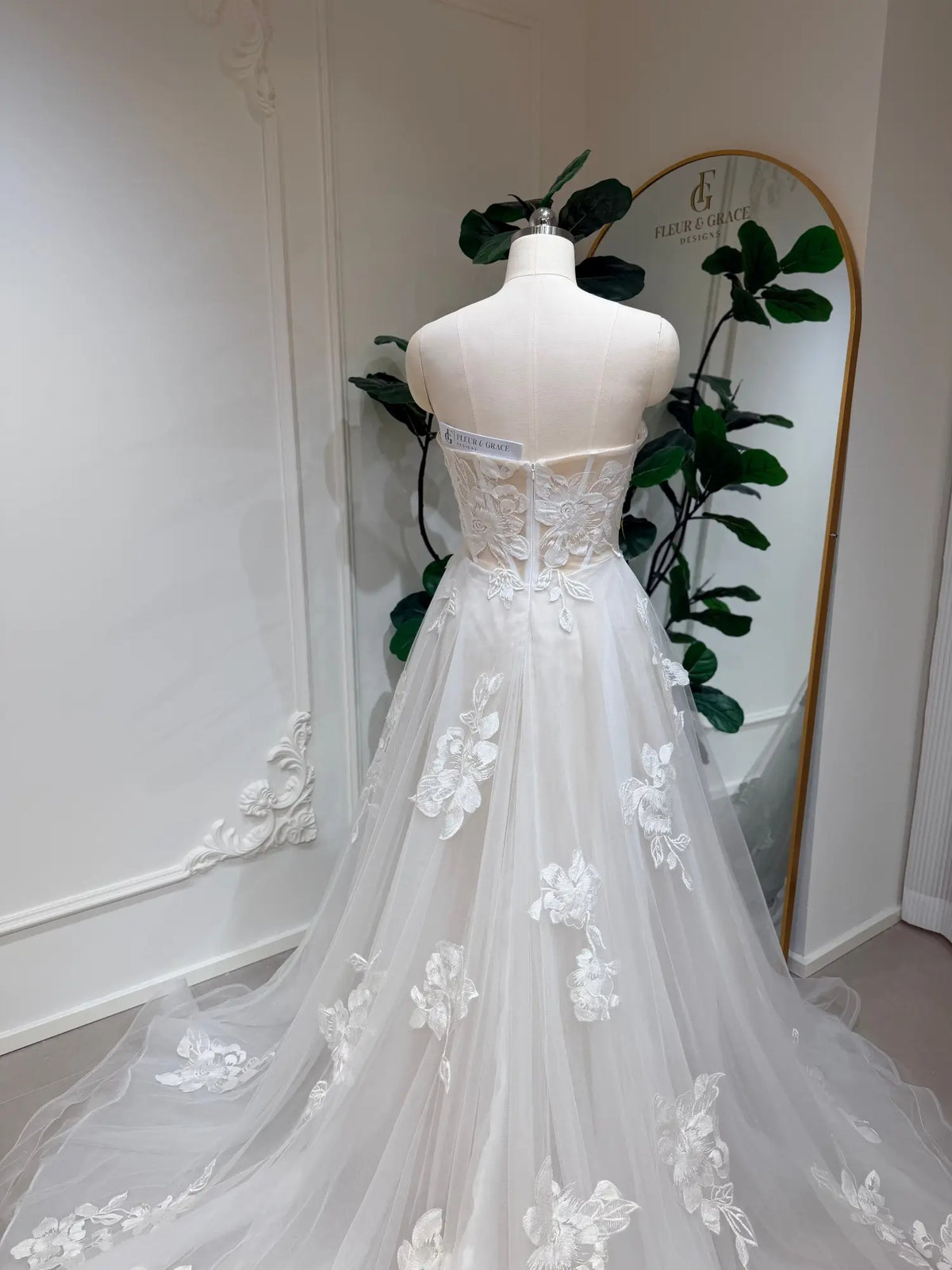Strapless A-line wedding dress with 3D floral lace appliqués on a white tulle skirt and sweetheart bodice.