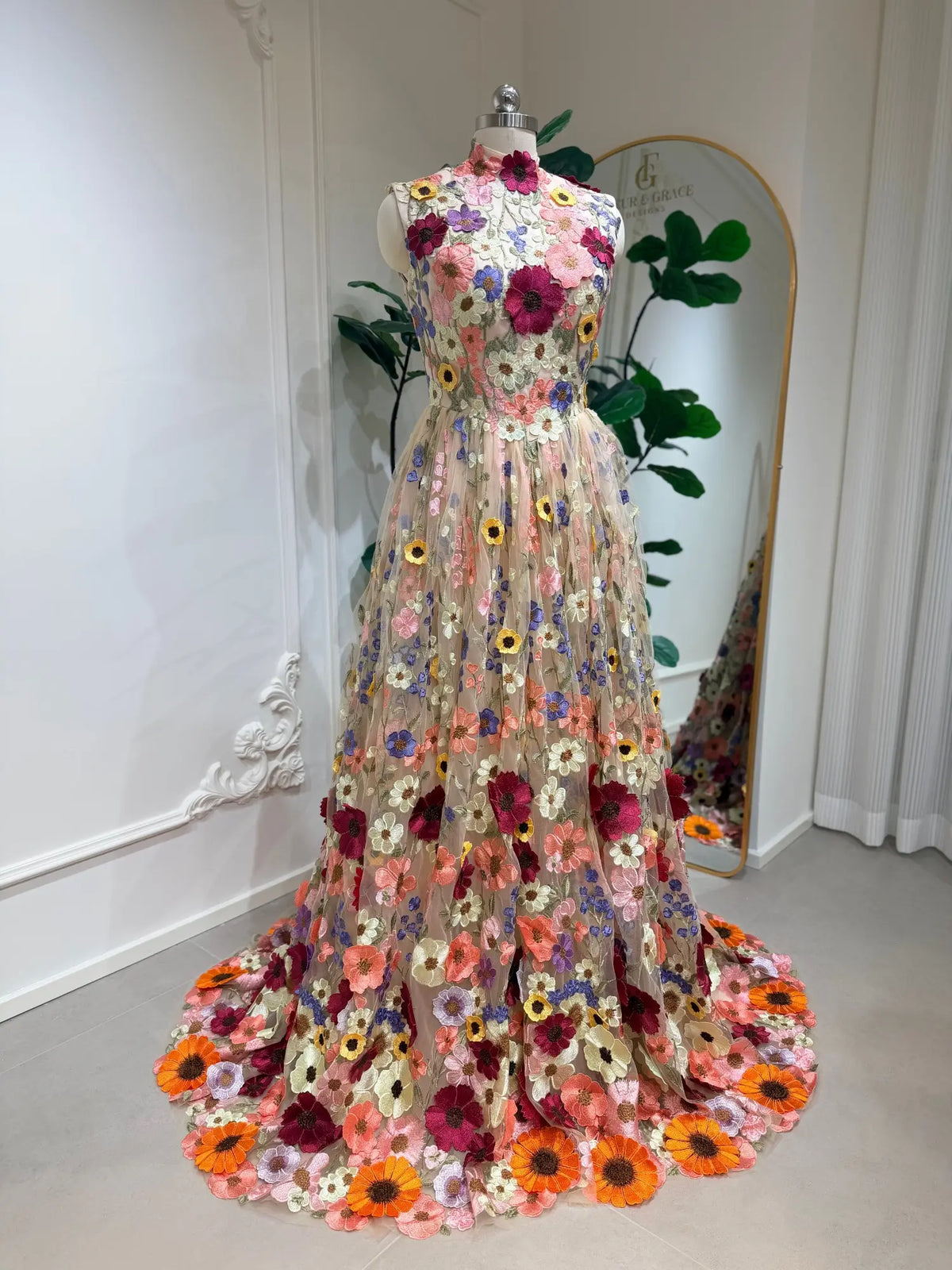 High-neck A-line wedding dress featuring colorful 3D floral embroidery on a sheer tulle bodice and flowing skirt.