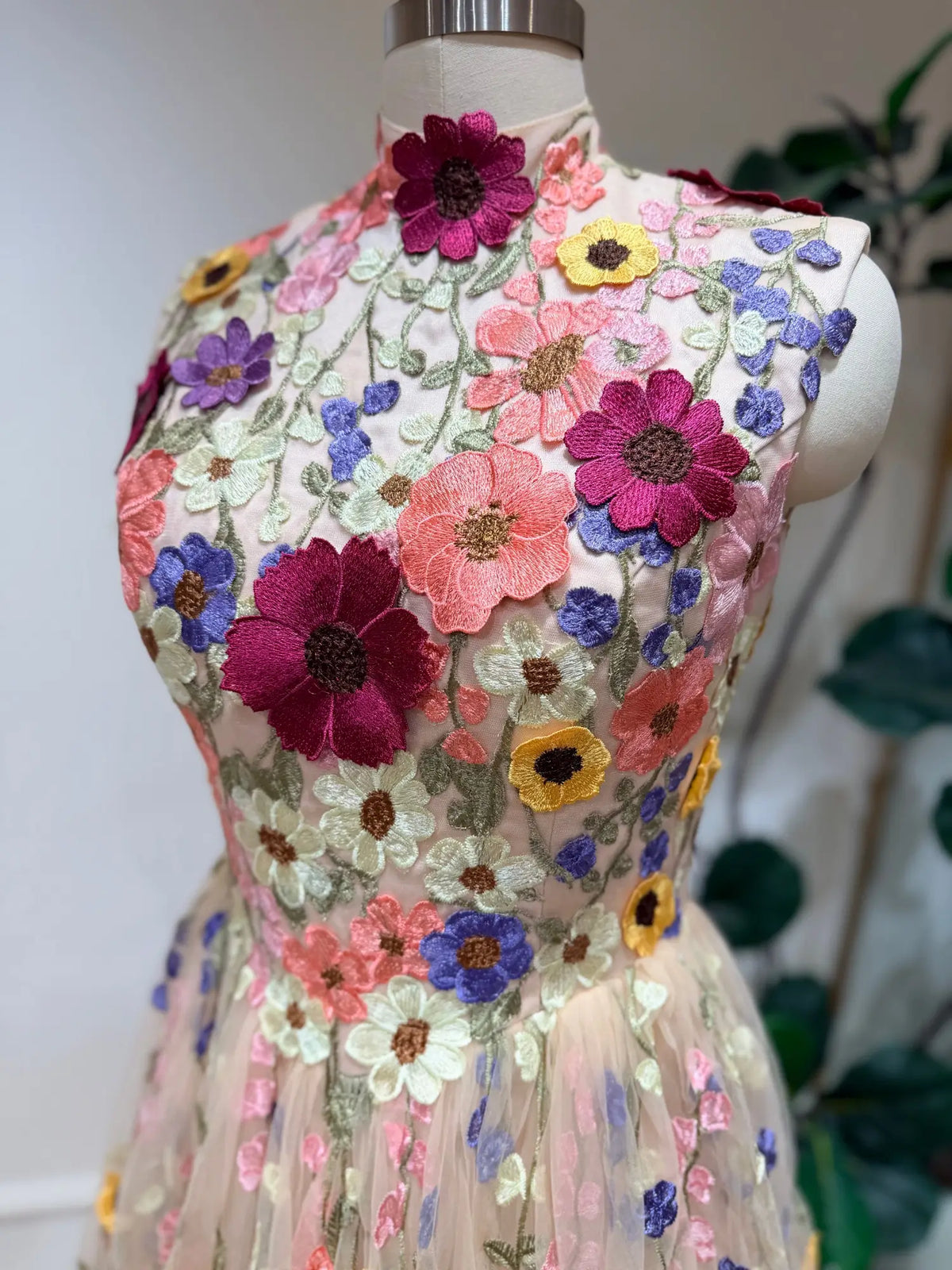 High-neck A-line wedding dress featuring colorful 3D floral embroidery on a sheer tulle bodice and skirt.