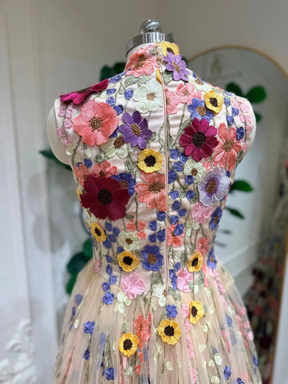 High-neck wedding dress featuring vibrant 3D floral embroidery on a sheer tulle bodice and flowing A-line skirt.