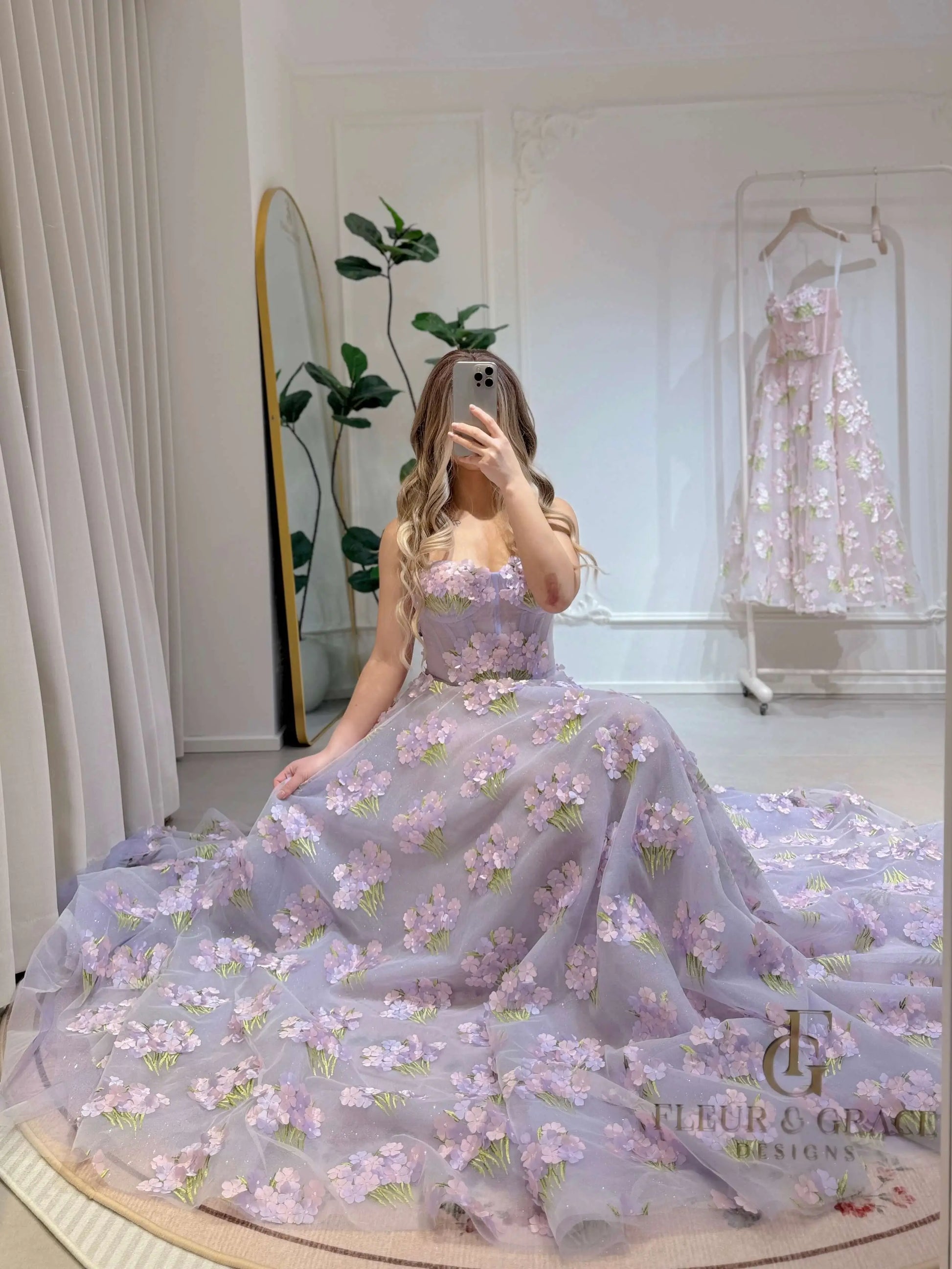 Model wearing the Lavender Elysia Gown FG016 by Fleur&Grace Designs – floor-length lavender dress with 3D hydrangea floral lace, sparkly mesh lining, and lace-up back, perfect for prom, garden weddings, formal evenings, and whimsical photography.
