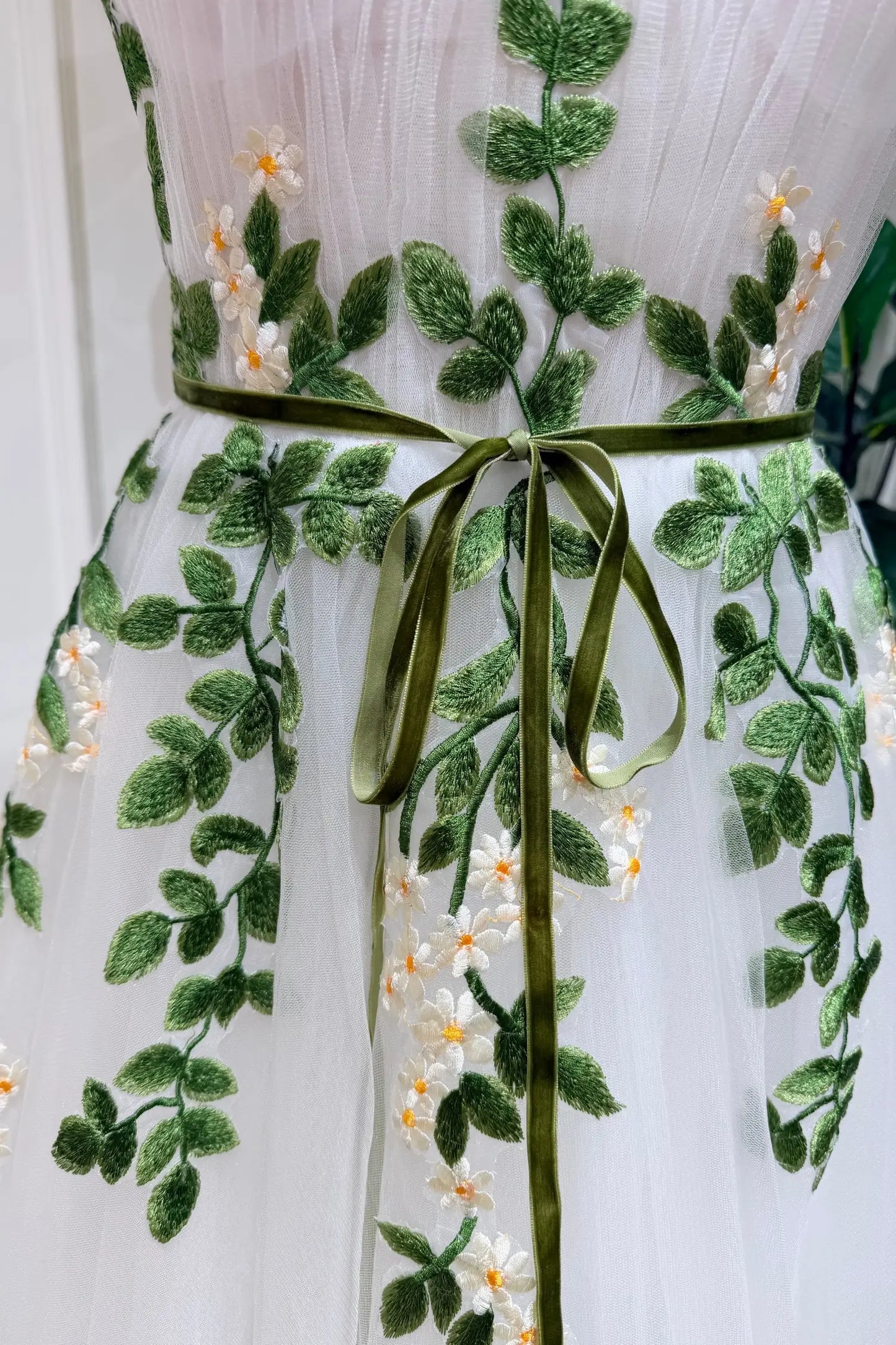 Elve Gown by Fleur&Grace Designs — ivory tulle A-line forest elopement wedding dress with sweetheart neckline, pleated bodice, daisy embroidery straps, green belt, and side pockets.