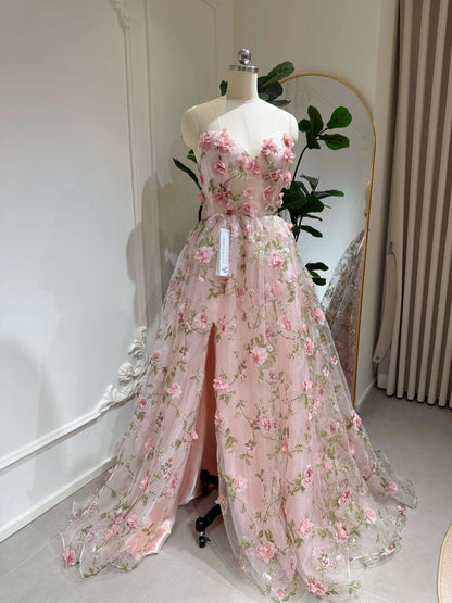 The Pink Rosa Gown FG013 made by Fleur&amp;Grace s a stunning 3D floral lace prom dress designed for elegance and charm. Made with delicate&nbsp;organza lace featuring meadow green leaf prints and sparkly mesh, this gown is perfect for prom, formal events, and photography. The sweetheart neckline and boned bodice provide a structured, flattering fit, while the lace-up back ensures adjustability. Designed with removable short puffy sleeves, pockets, and a side slit, this dress combines beauty and functionali