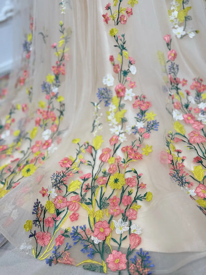 Champagne tulle wedding dress with vibrant, hand-embroidered multicolor botanical floral appliqués.