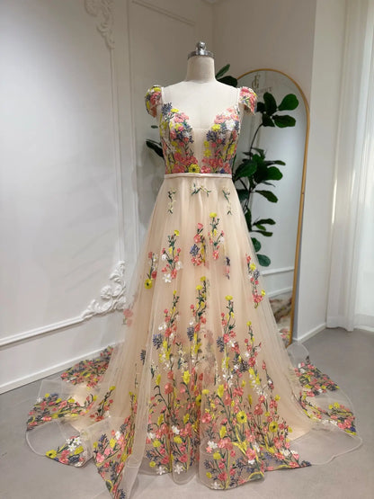 Champagne A-line wedding dress with colorful floral embroidery, cap sleeves, and a flowing tulle skirt on a mannequin.