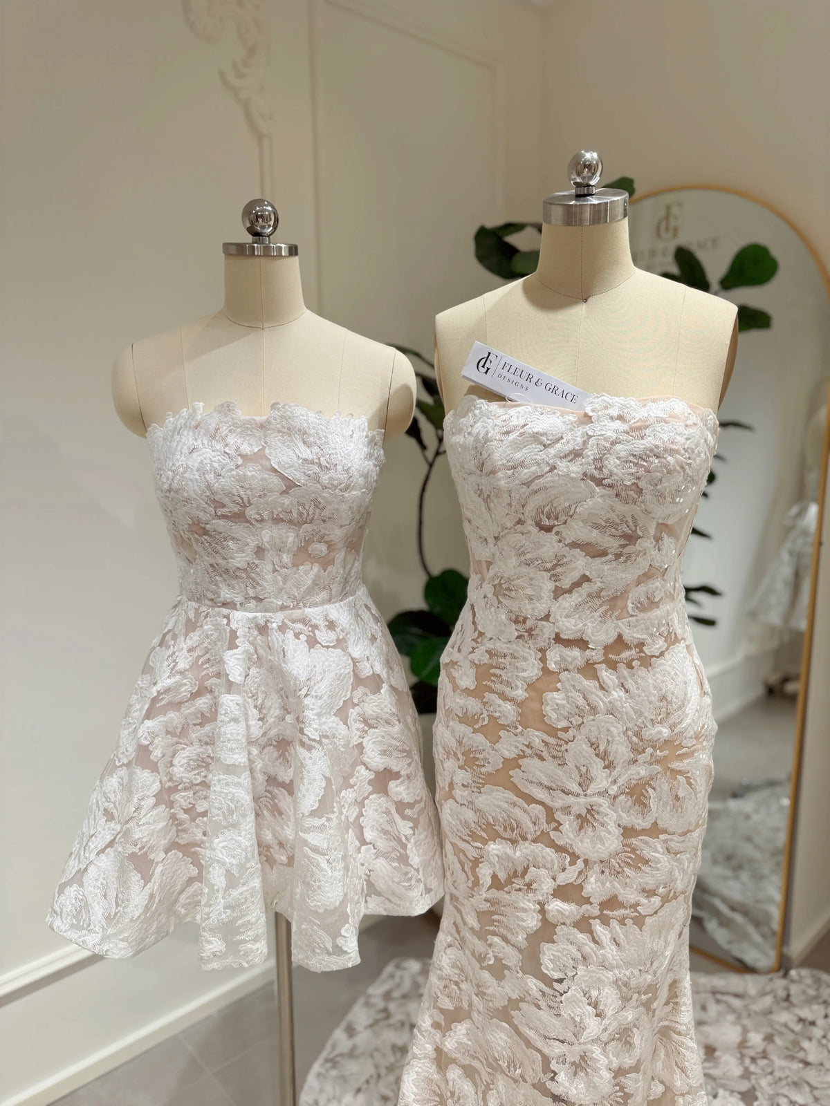 Strapless mermaid and short wedding dresses with white floral embroidery and glitter sequins on mannequins.