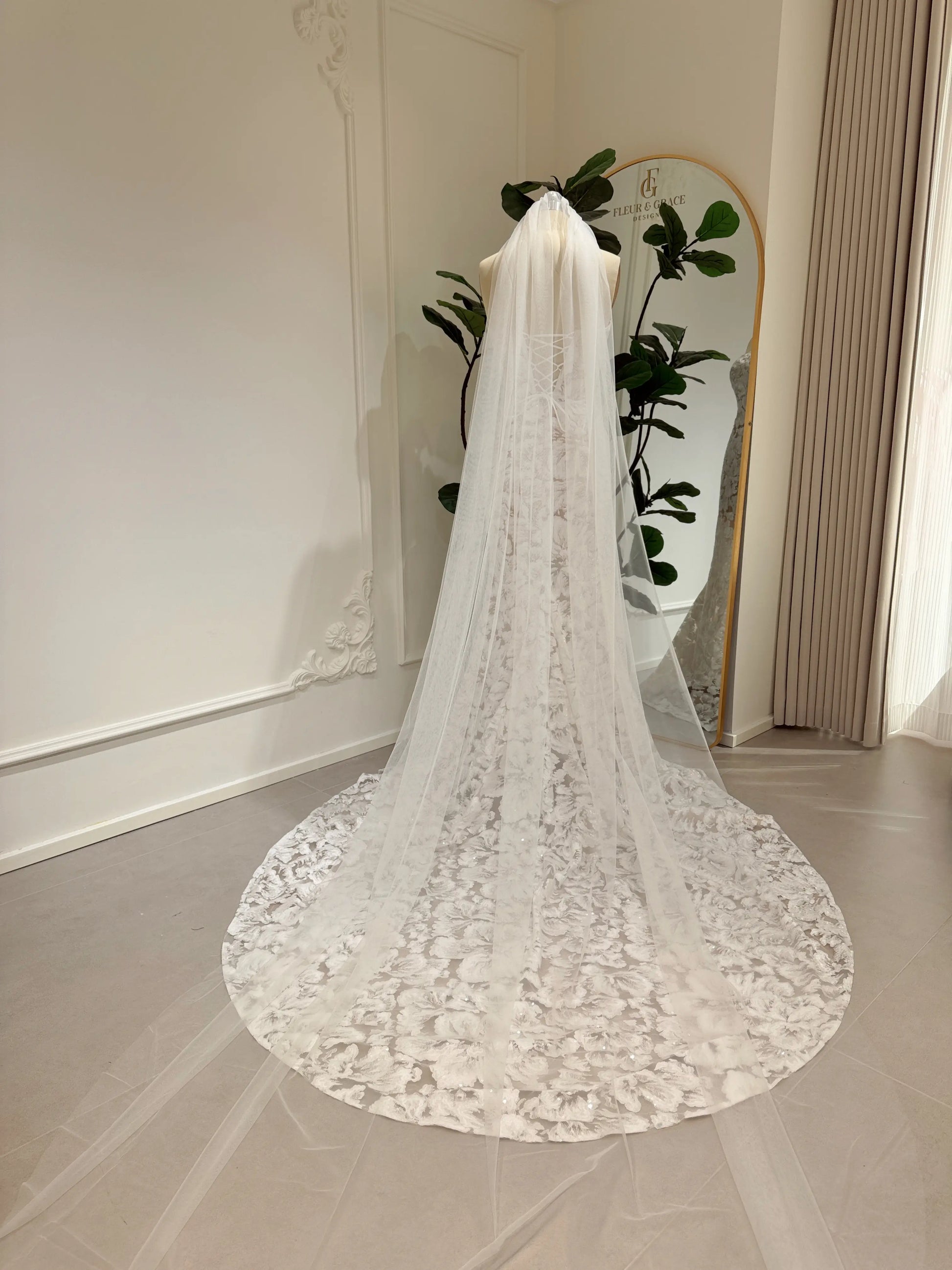 Mannequin wearing the Jane Gown by Fleur&Grace Designs – strapless mermaid wedding dress with floral embroidered lace, glitter sequins, lace‑up back, and chapel‑length train.