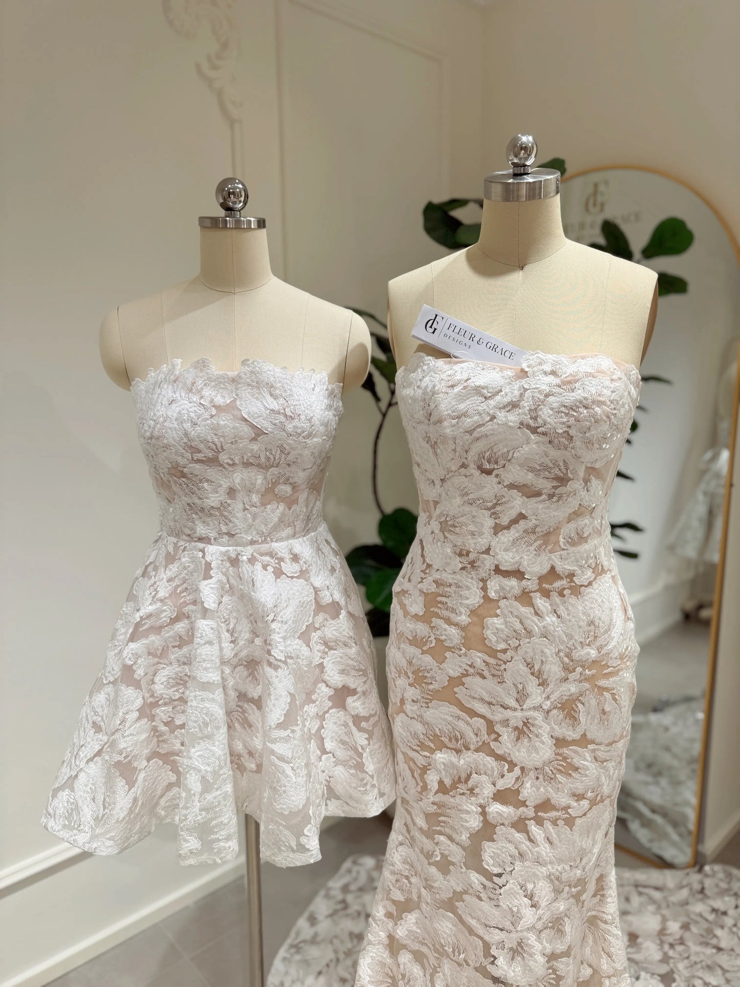 Mannequin wearing the Jane Gown by Fleur&Grace Designs – strapless mermaid wedding dress with floral embroidered lace, glitter sequins, lace‑up back, and chapel‑length train.