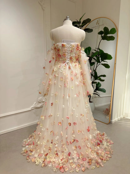 Pink floor-length wedding gown with 3D floral appliqués, removable sleeves, and a lace-up back on a dress form.