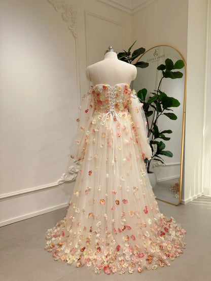 Pink floor-length wedding gown with 3D floral appliqués, removable sleeves, and a lace-up corset back on a mannequin.