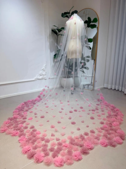 Cathedral-length bridal veil in soft illusion tulle featuring handmade blush pink 3D flowers on a mannequin.