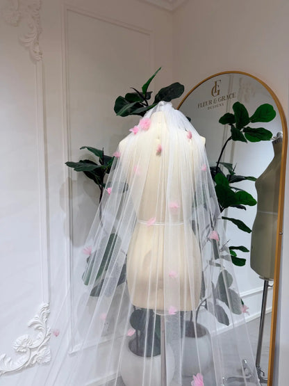 Cathedral-length bridal veil in soft illusion tulle featuring handmade blush pink 3D flowers on a mannequin.
