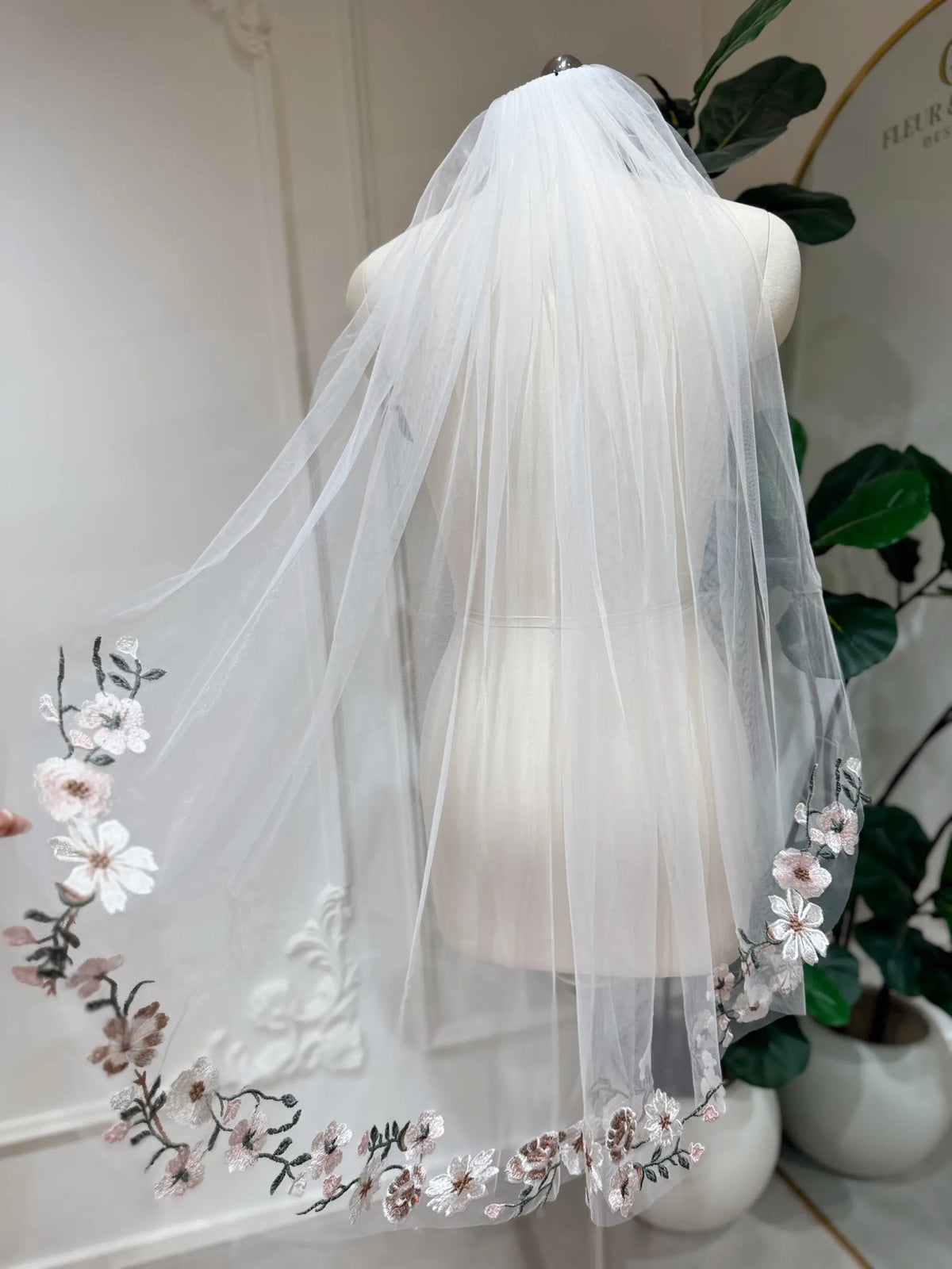 Sheer champagne tulle bridal veil featuring delicate multicolored floral embroidery along the scalloped edges.