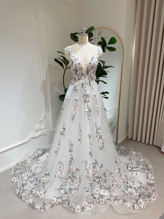 Kate Gown wedding dress with floral embroidery on tulle, V-neckline, and a flowing chapel-length train on a mannequin.