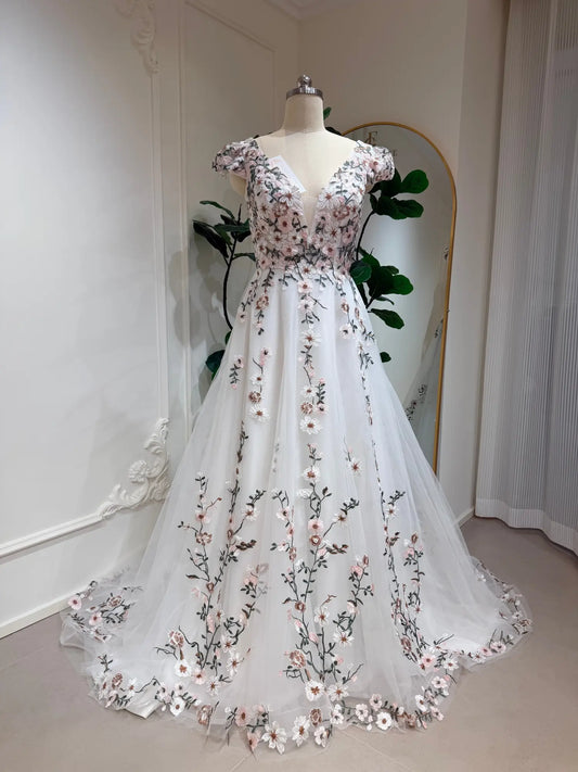 A-line wedding dress with cap sleeves, deep V-neck, and delicate 3D floral embroidery on white tulle.