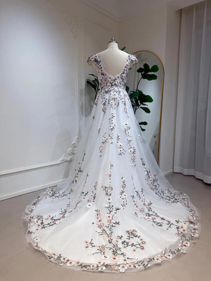 A-line wedding gown with cap sleeves, featuring 3D floral embroidery on white tulle and a graceful chapel train.